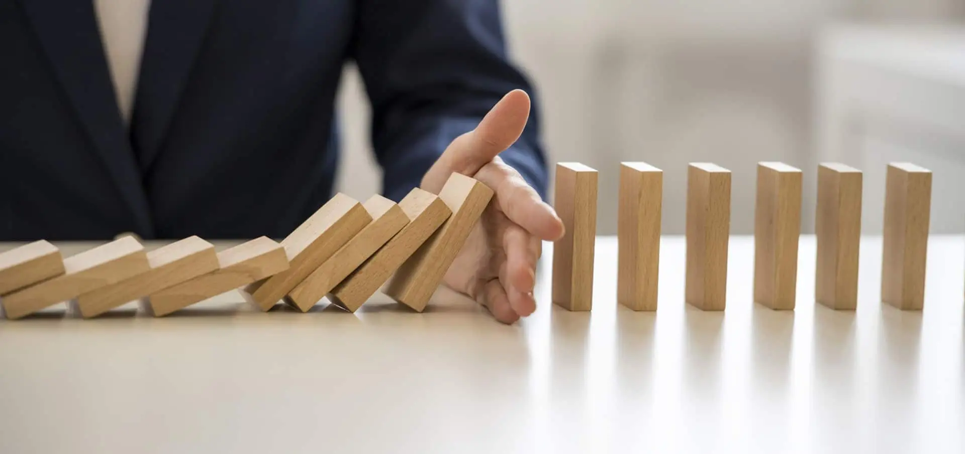 Wood blocks falling and mans hand stopping them