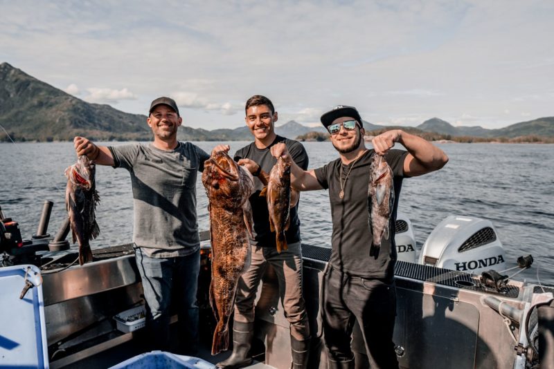 three guys fishing on a boat at Salmon Falls Resort Alaska