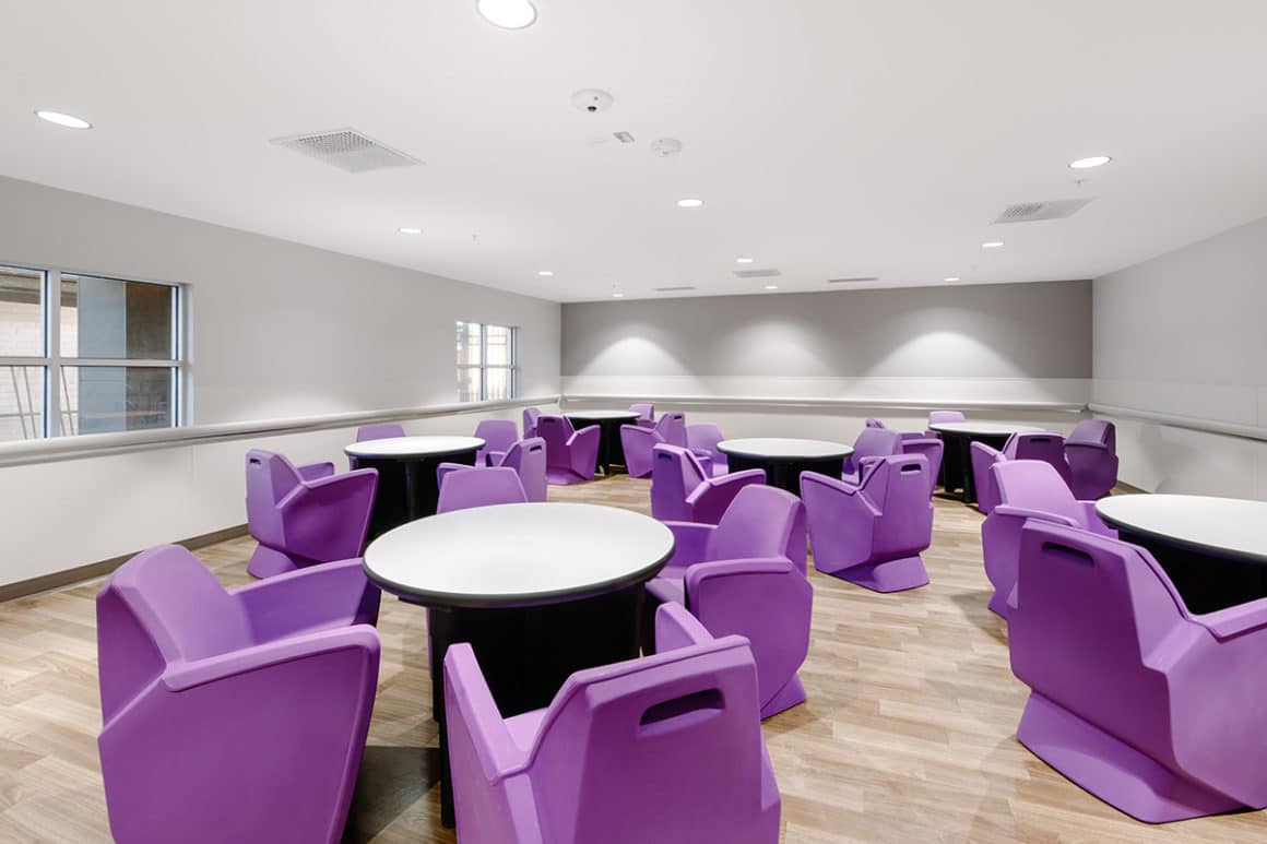 A common area built in the hospital with many tables and chairs to sit in