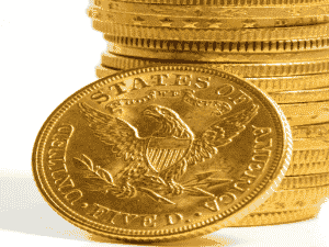 gold U.S coins stacked upon one another with a whitebackground