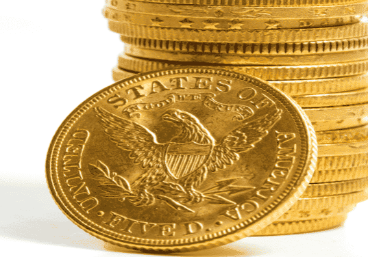 gold U.S coins stacked upon one another with a whitebackground