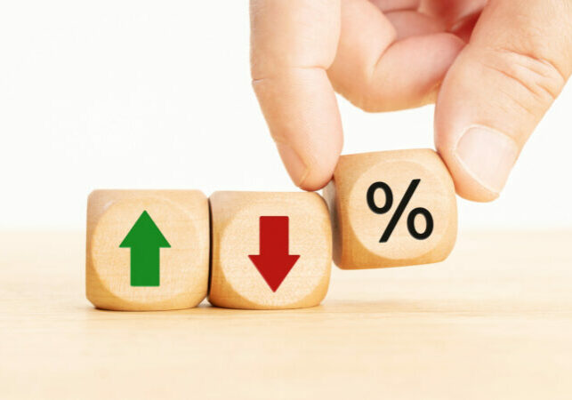 Stock market, Business and finance concept. Hand holding a Wooden block with percent, up or down arrow icons
